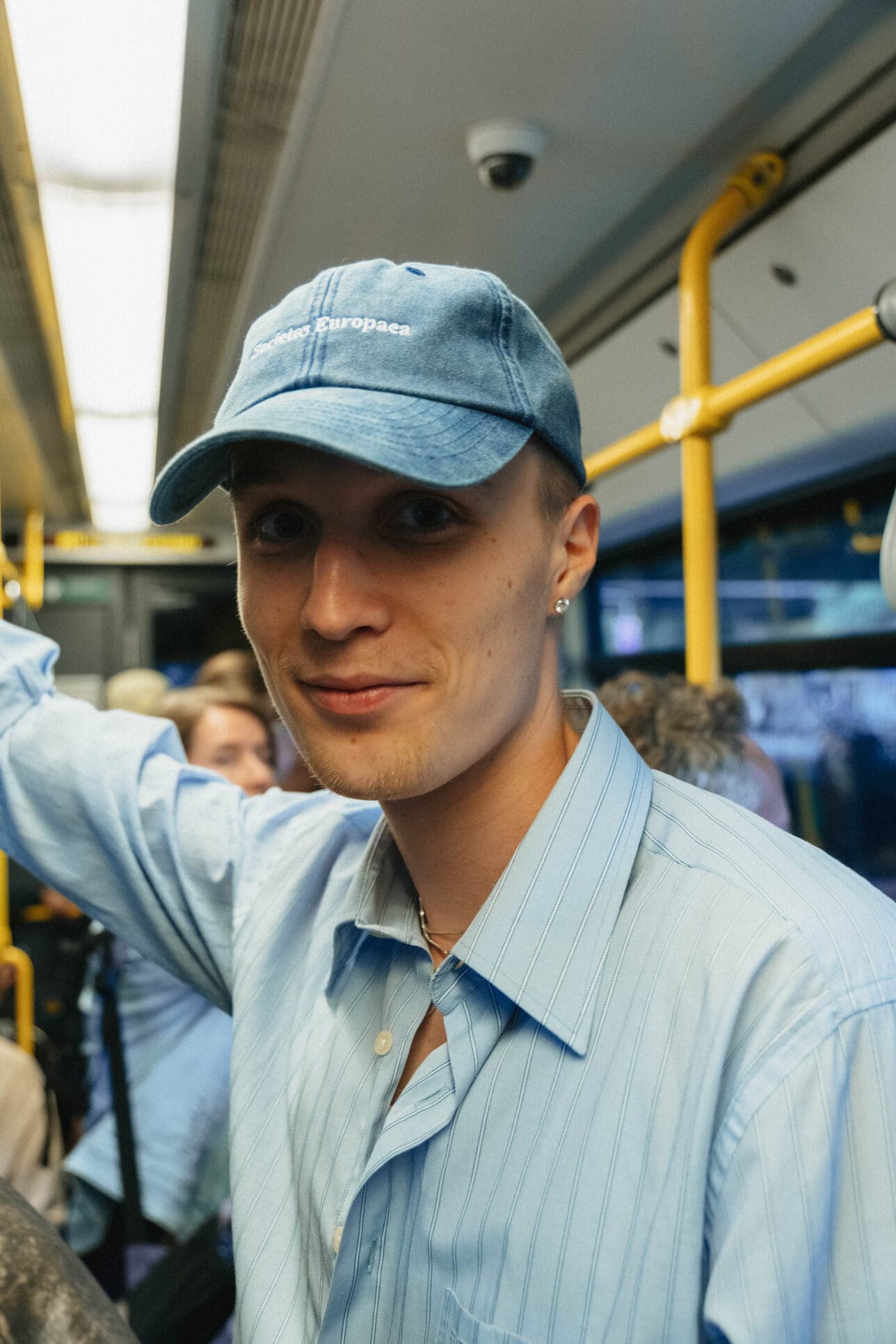 A teammate wearing a blue cap on a tram.