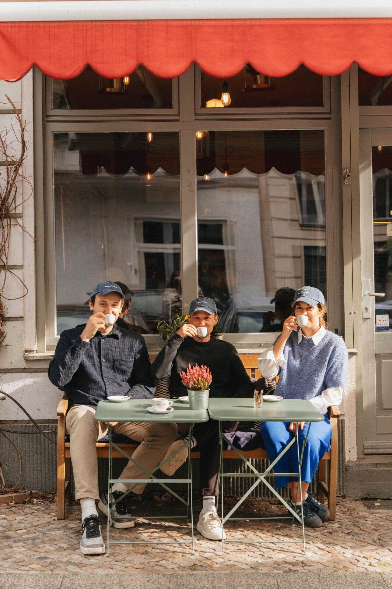 Teammates talking around a café terrace table.