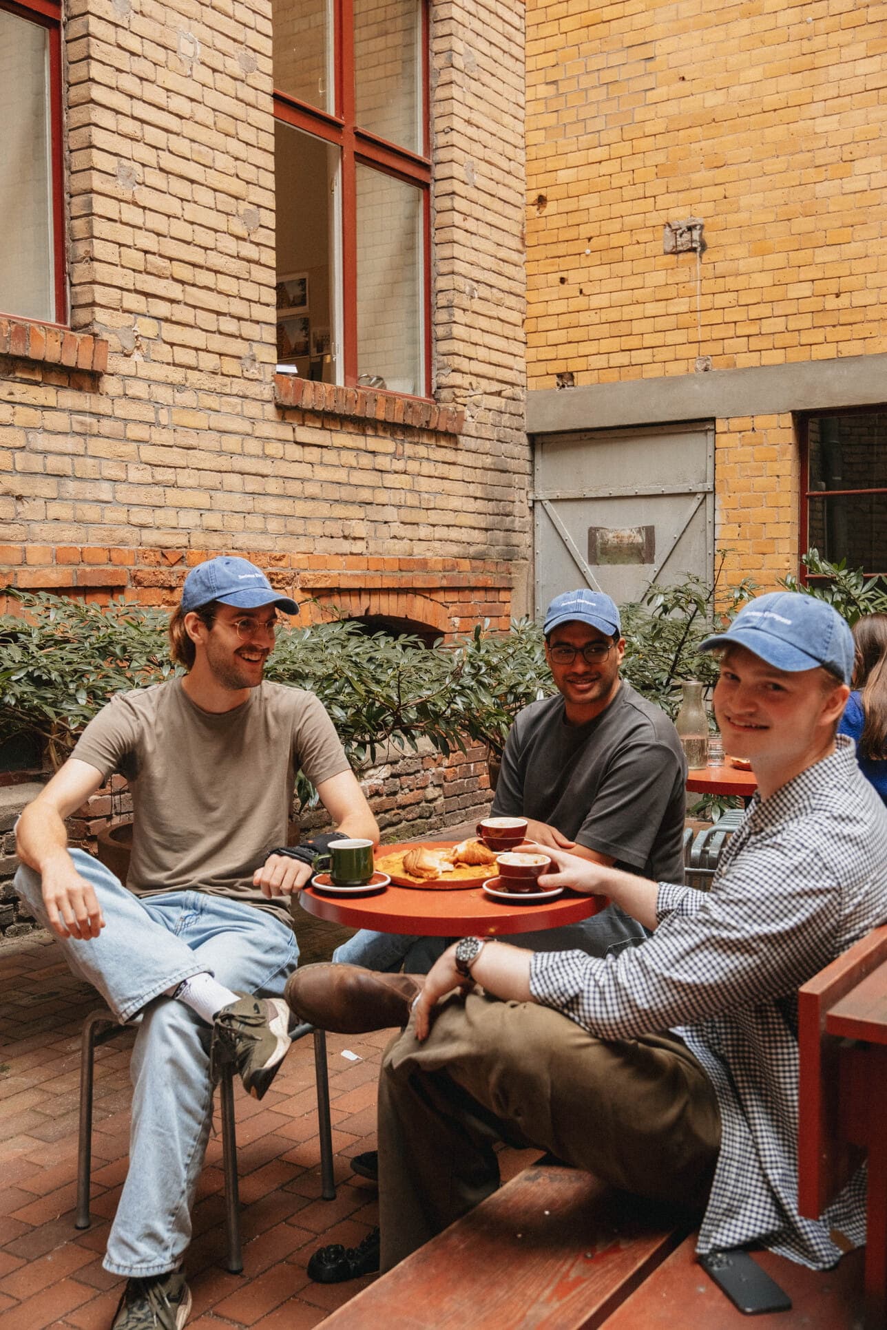 Teammates sharing lunch in a brick courtyard.