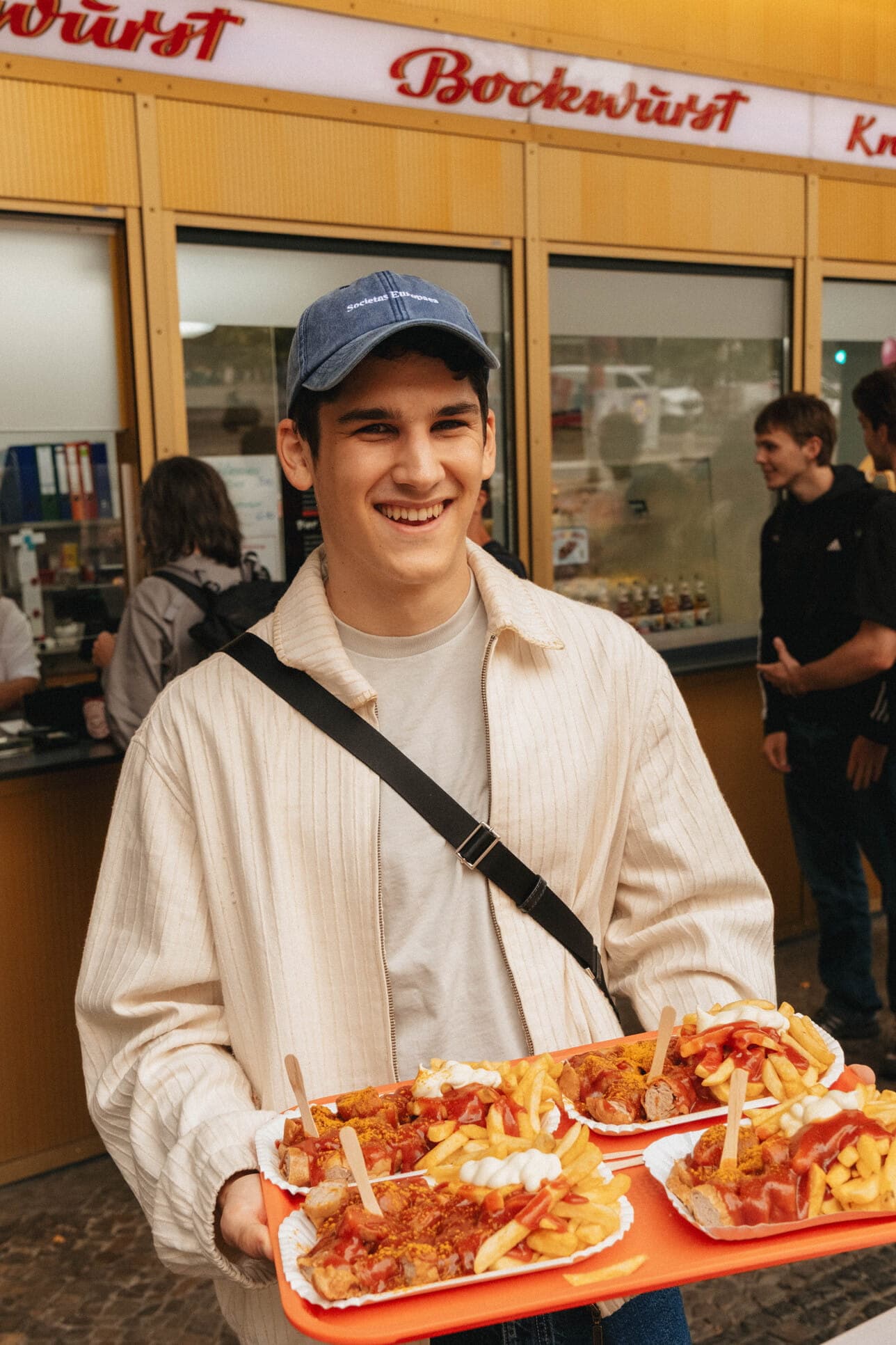 A teammate holding a tray of currywurst.
