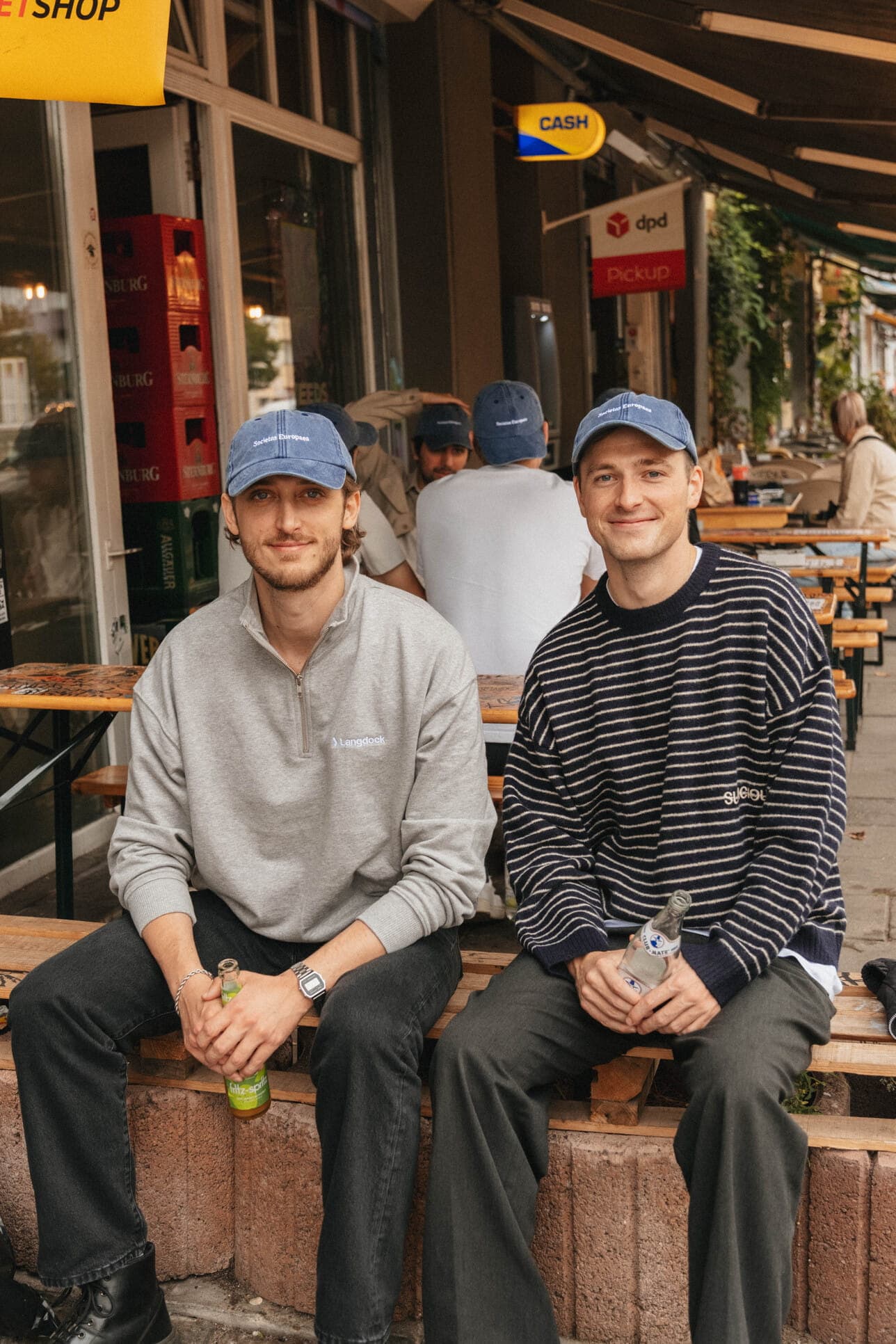 Two teammates sitting outside a café.
