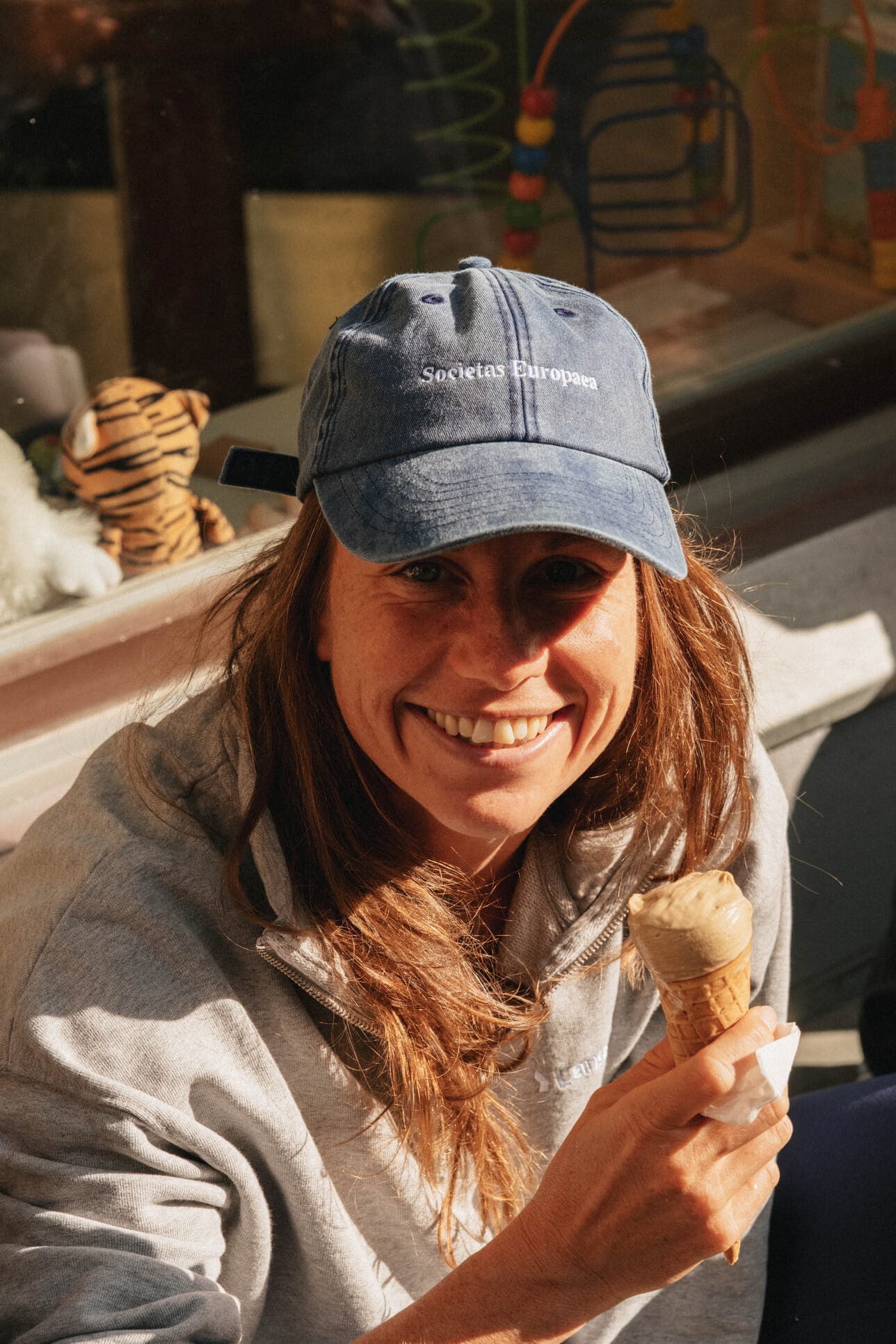 A smiling teammate at a sunny café table.