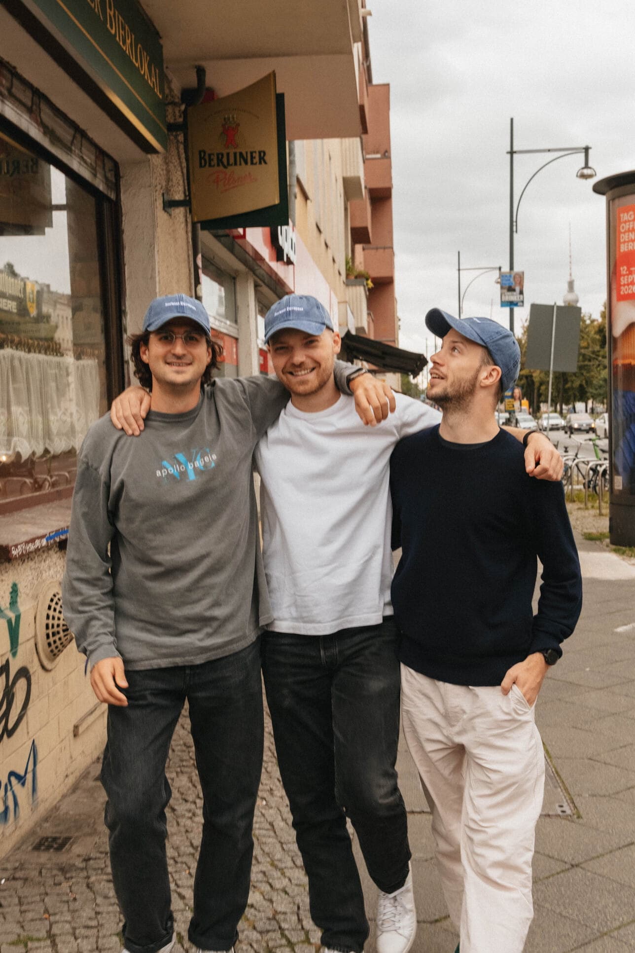 Three teammates together on a city sidewalk.