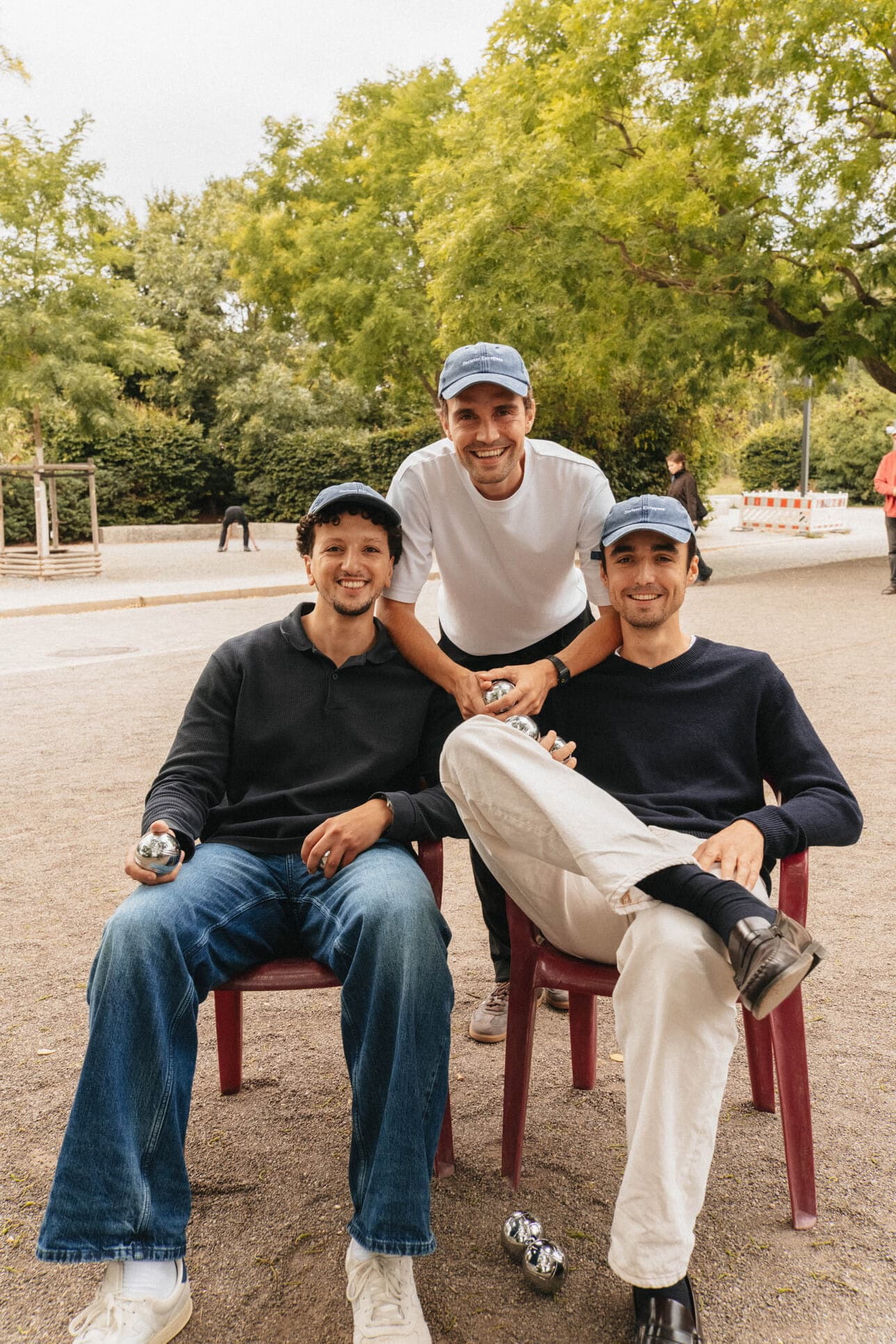 Three friends sitting together outdoors.